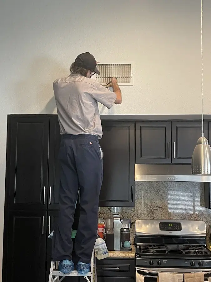 Technician inspecting an air vent during HVAC service in Claverack